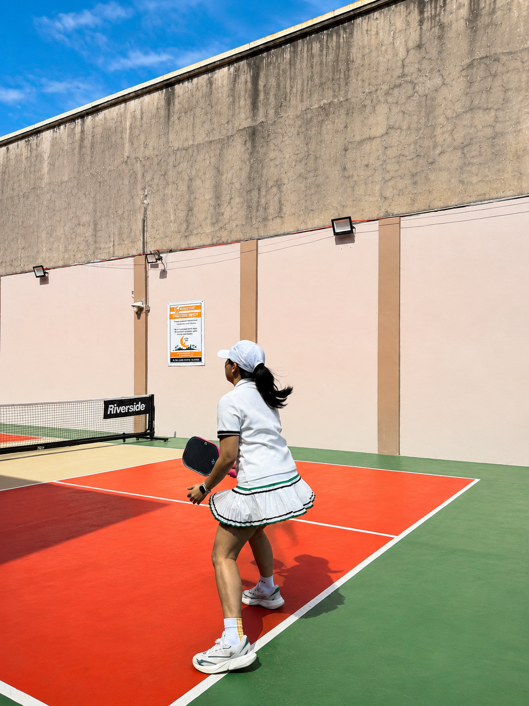 Genevieve mid-rally on the pickleball court, paddle ready.